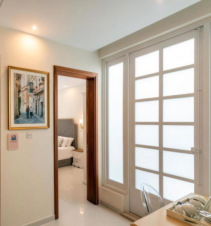a room with a large window and a bedroom at Ta' Nina Boutique in Mdina