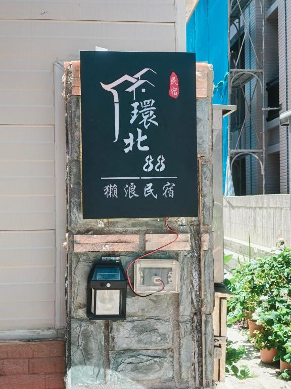 a sign on the side of a building with a meter at Kinmen Huan Bei 88 B&B in Jincheng