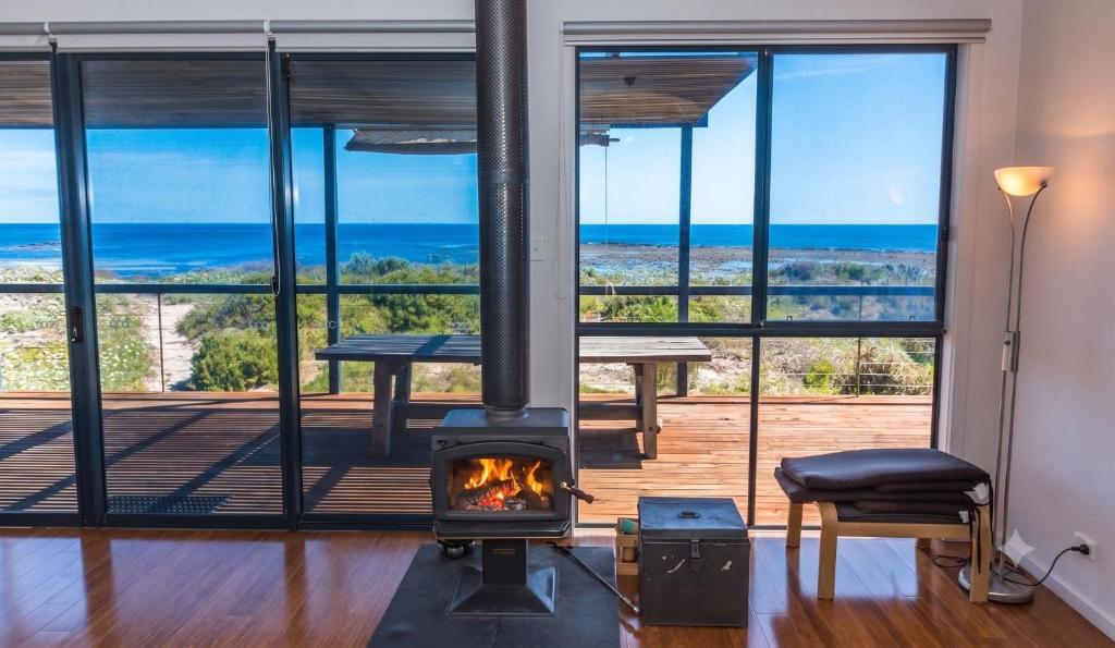 a fireplace in a living room with a view of the ocean at 20 Lady Bay Road in Normanville