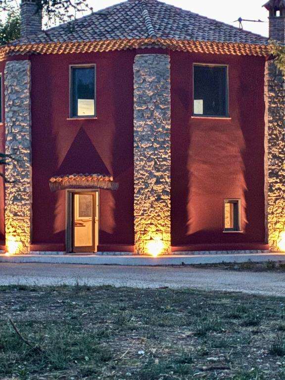 a red house with a front door with lights at Fattoria solidale del Circeo in Pontinia