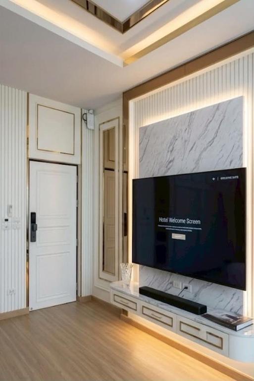a living room with a large flat screen tv on a wall at Nong Bua Lam Phu Residence Hotel in Nong Bua Lamphu