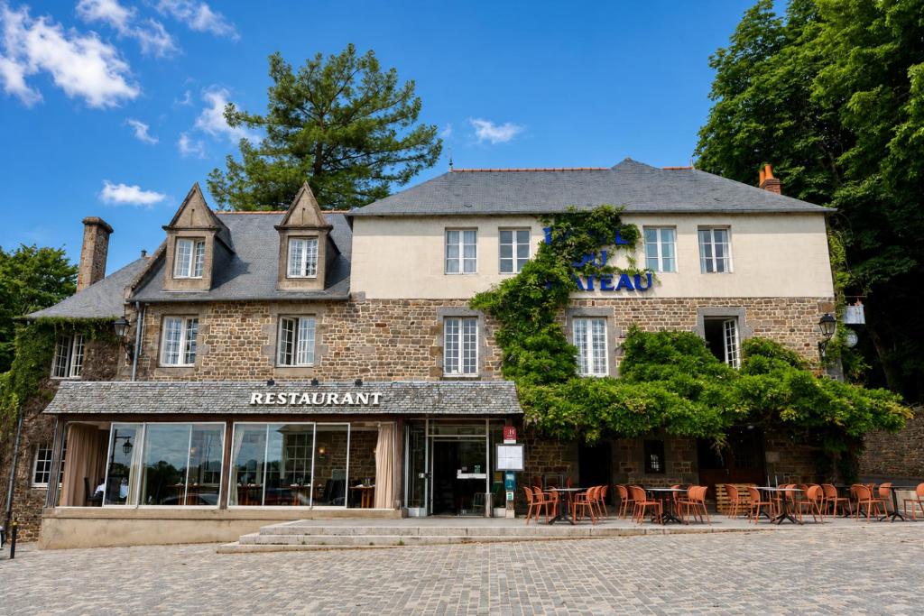 a building with tables and chairs in front of it at Logis Hôtel Du Château - Combourg, Proche Saint-Malo in Combourg