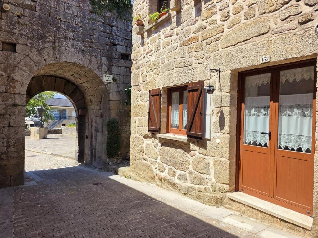 a stone building with a door and an archway at Cantinho da Muralha in Melgaço