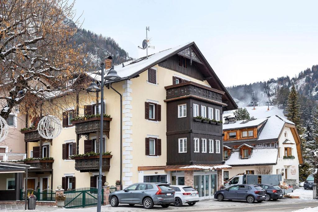 a large building with cars parked in front of it at Apartments Mupan St. Vigil in San Vigilio Di Marebbe