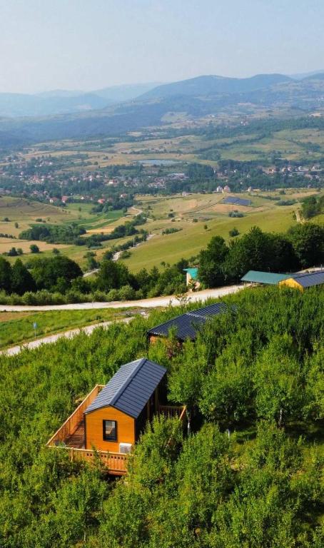 an orange house on top of a green hill at Malak Farma in Kakanj
