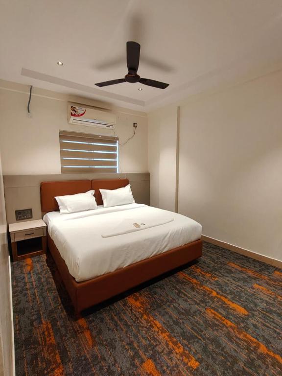 a bedroom with a large bed with a ceiling at SW Hotel MG Road in Bangalore