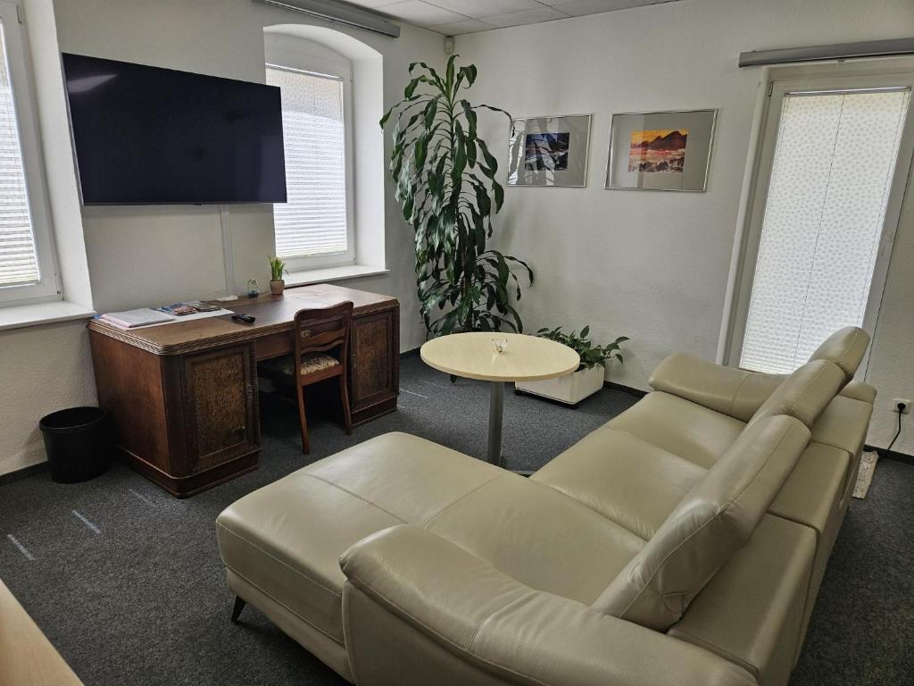 a living room with a couch and a table and a desk at Krämerbrückenidyll in Erfurt
