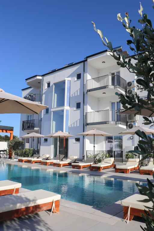 a building with a swimming pool next to a resort at Velipoja Residences in Velipojë