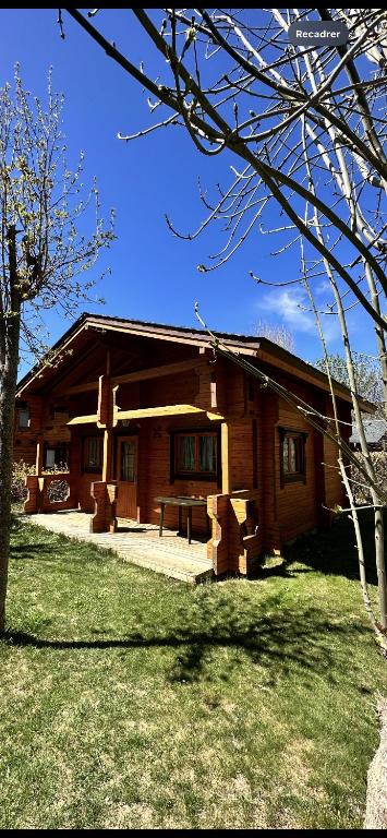 a wooden house with a bench in front of it at Chalet 2 chambres à Estavar in Estavar