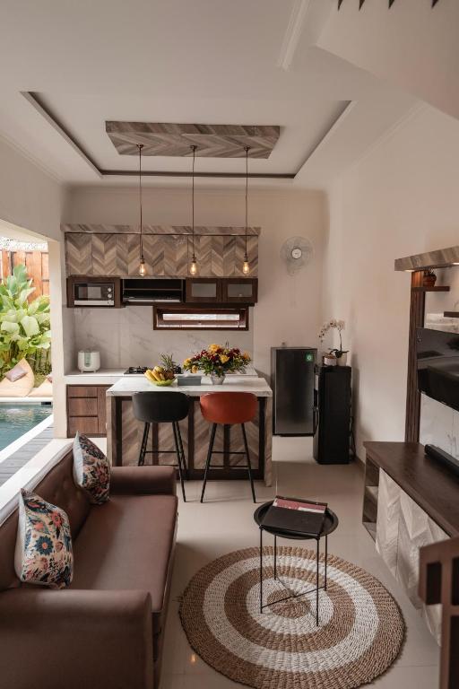 a kitchen and living room with a couch and a table at oemah samiya in Keramas