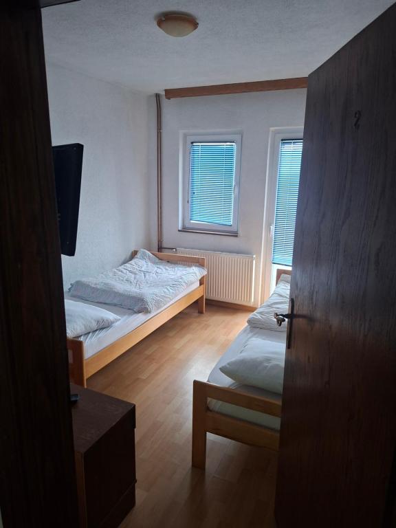 a small bedroom with two beds and a window at VRATA IGMANa in Hadžići