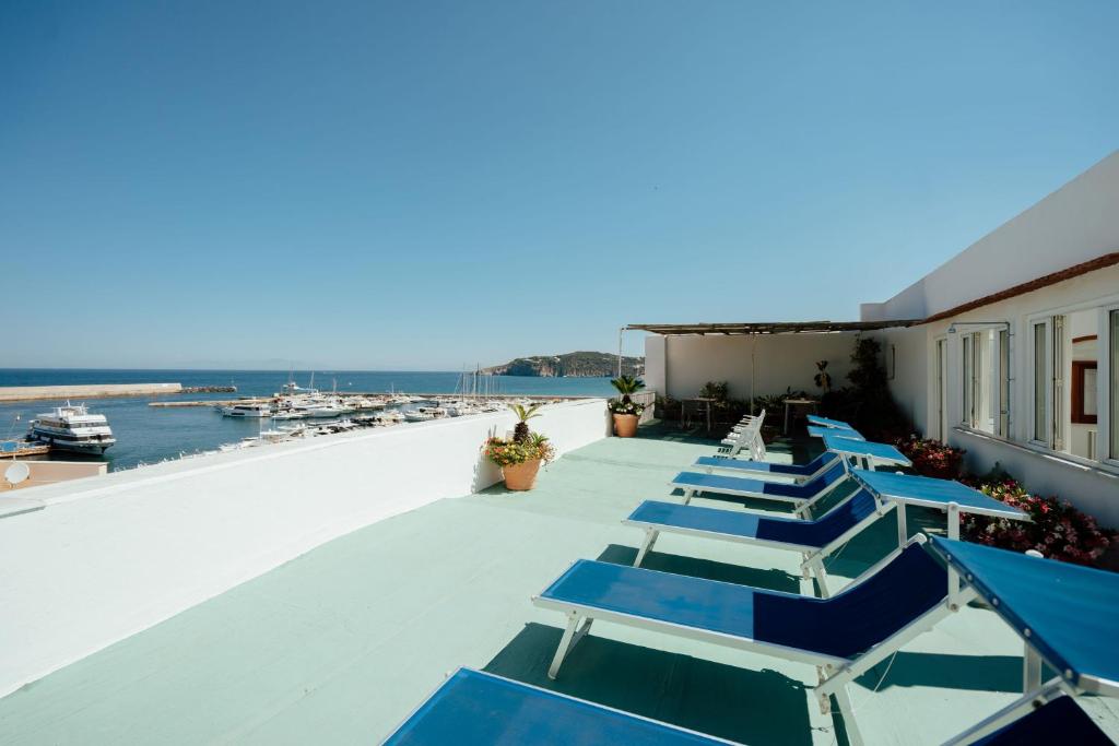 a row of blue lounge chairs on the roof of a building at Pensione Di Lustro in Forio d'Ischia