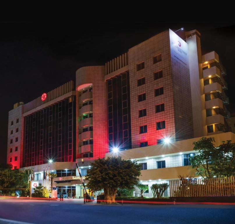 a large building with red lights in front of it at Lancaster Tamar Hotel- Hadath in Beirut