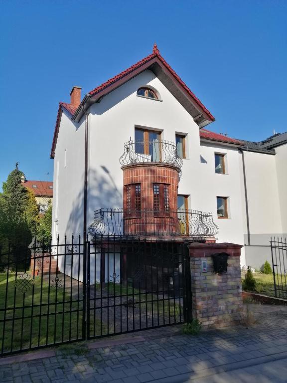 a large white house with a black fence at Apartament Orłowo in Gdynia