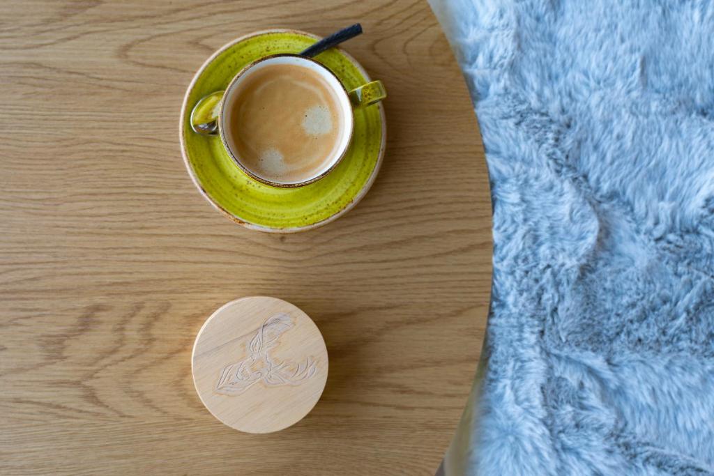 a cup of coffee on a table next to a blanket at Apartment BergStyle in Pfronten