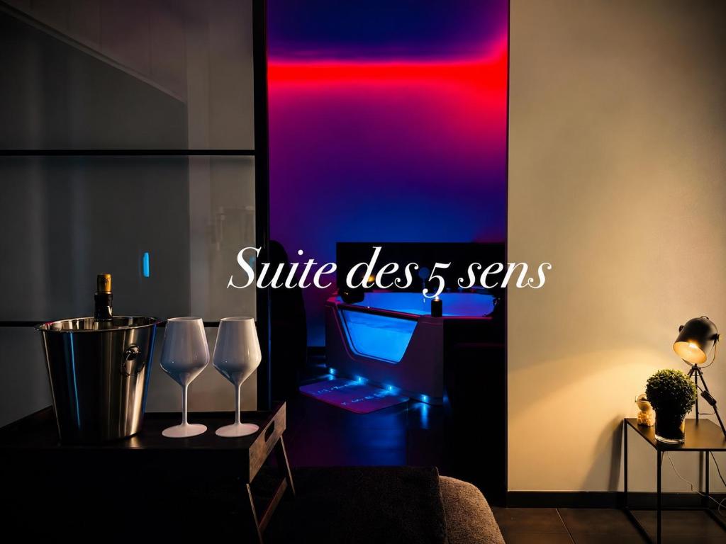 a room with a table with two wine glasses on it at Jacuzzi, massage et plage ! in Fréjus