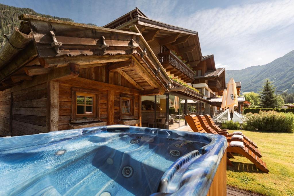 ein Blockhaus mit einem Whirlpool davor in der Unterkunft Hotel & Residence Rose in Sterzing