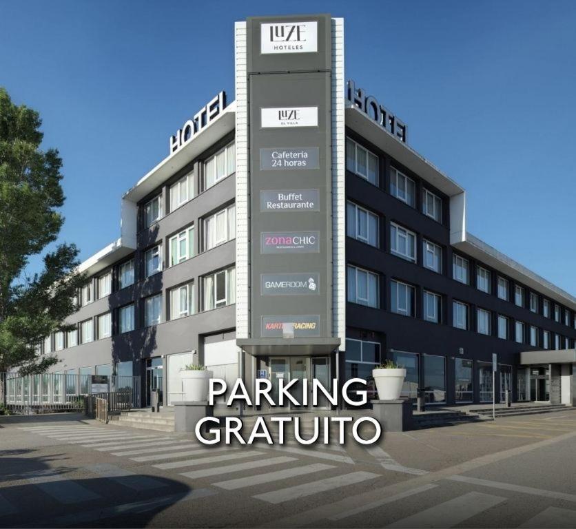 a building with a parking sign in front of it at Hotel Luze El Villa in Castejón
