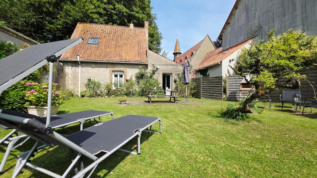 a picnic table in the yard of a house at Domaine Les Tourelles - La petite maison in Caffiers