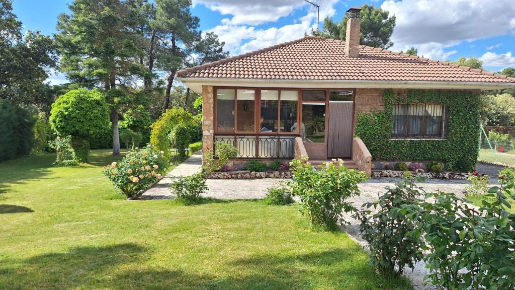 a small house with a porch in a yard at Chalet del Daniel en La Calabaza in Aranda de Duero