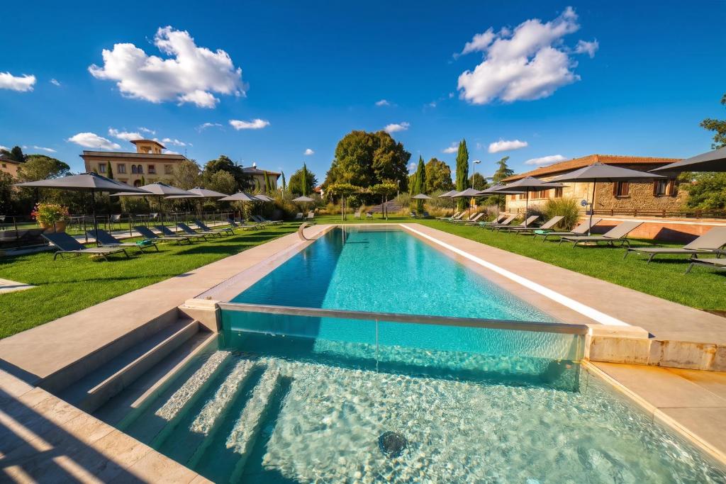 a swimming pool with blue water in a yard at Hotel Palazzo San Lorenzo & Spa in Colle di Val d'Elsa