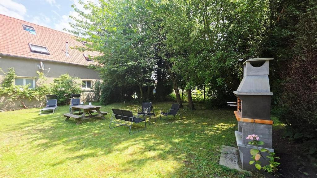 a yard with chairs and a table and a grill at Domaine Les Tourelles - Gîte 4 in Caffiers