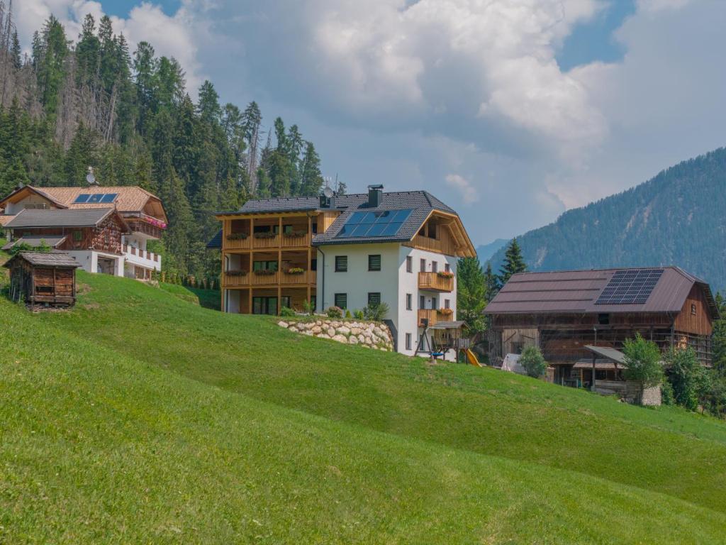 a group of buildings on top of a green hill at Lüch dl Chessl - Kesslhof in San Martino in Badia