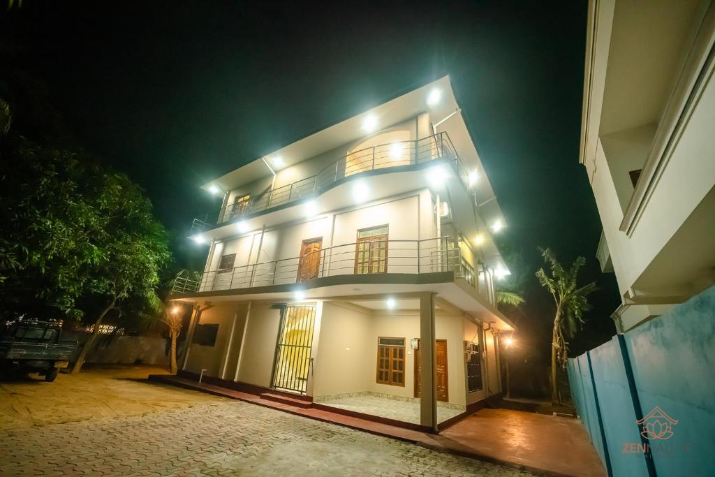 a large white building with a balcony at night at Zen Nallur in Jaffna