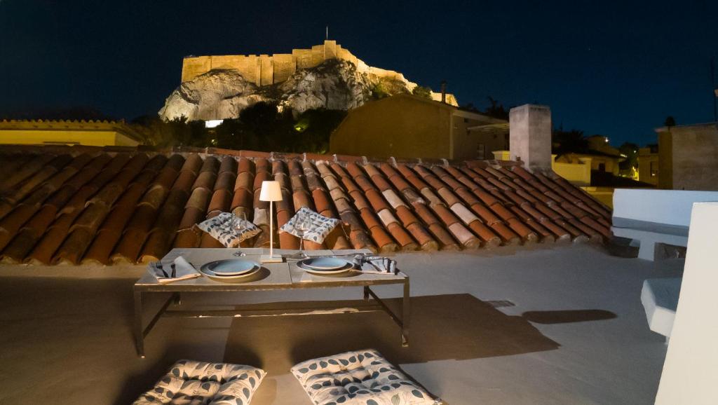 a table sitting on the roof of a building with a table sidx sidx at Acropolis Neoclassic Elegance in Athens