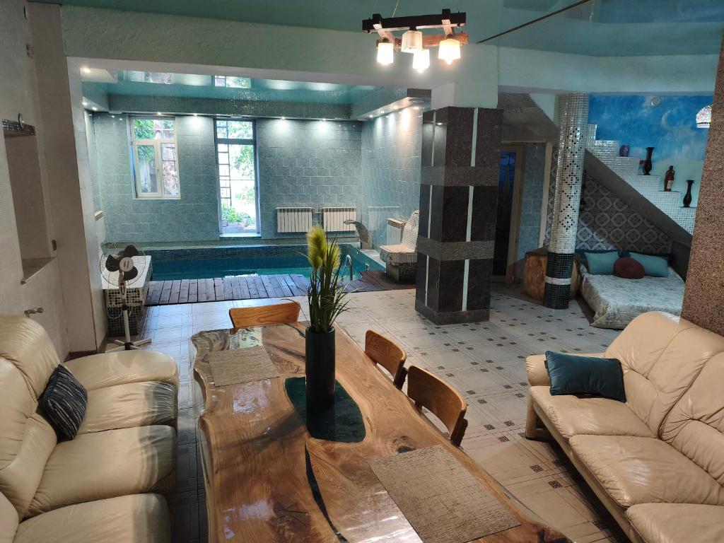 a living room with a wooden table and couch at Дом у моря с бассейном и сауной in Odesa