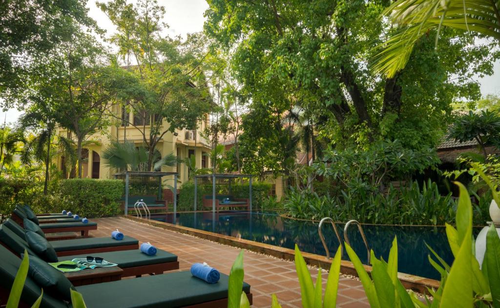 a resort with a swimming pool and trees at La Rivière d' Angkor Resort in Siem Reap