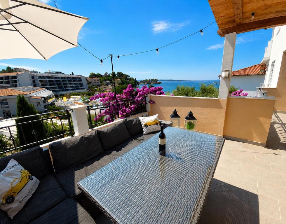 a table with a wine bottle on top of a balcony at Apartment Lučka II in Banjol