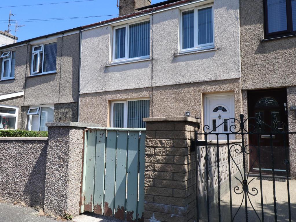 an apartment building with a gate and a fence at 31 Ffordd Y Maer in Pwllheli