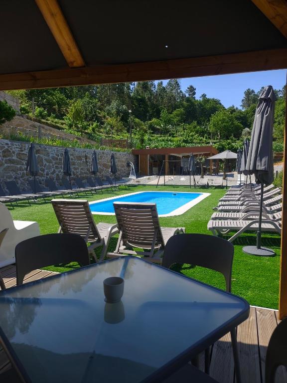 a table and chairs and a swimming pool at Quinta Cunha in São Pedro do Sul