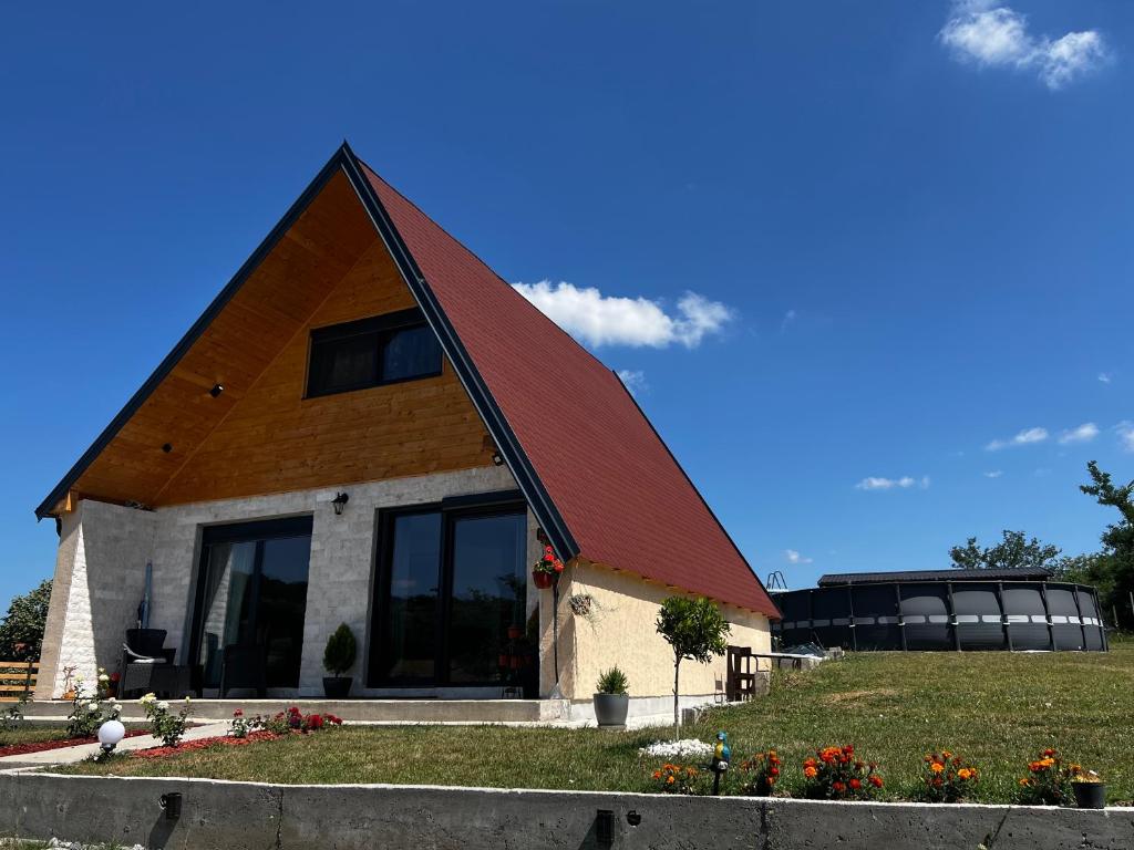 a house with a gambrel roof on a lawn at Kuća Sunny Rudnik in Rudnik