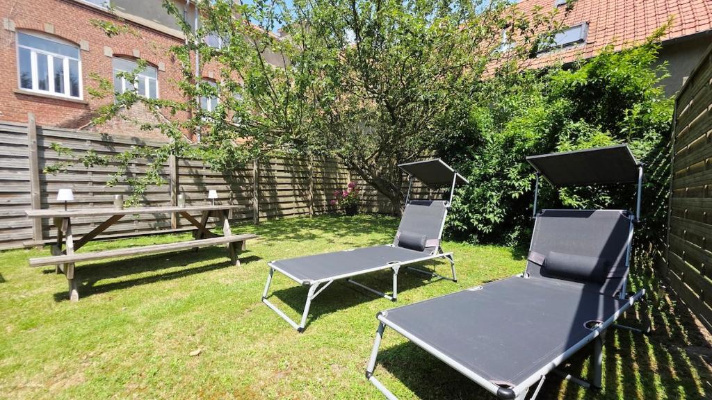two chairs and a picnic table and a bench in a yard at Domaine Les Tourelles - Gîte 3 in Caffiers