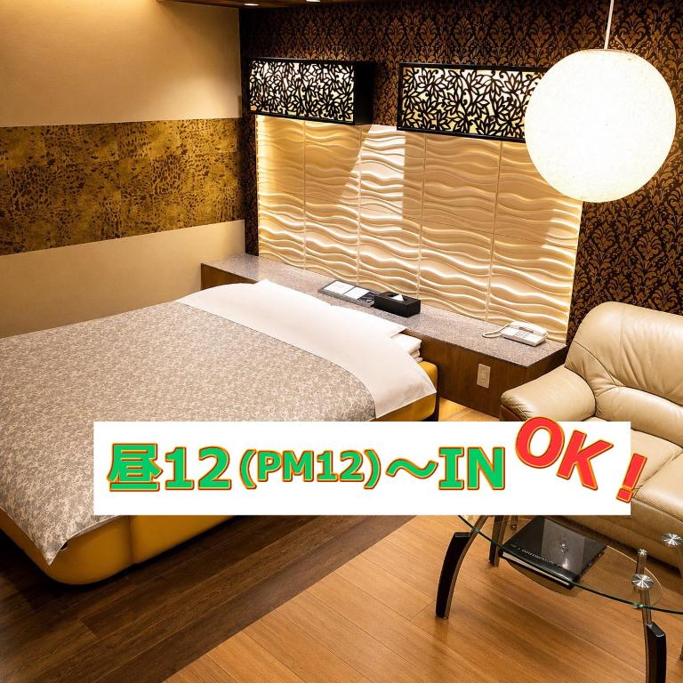 a bedroom with a bed and a desk and a chair at 名古屋北区のホテルコアラ in Tsujichō