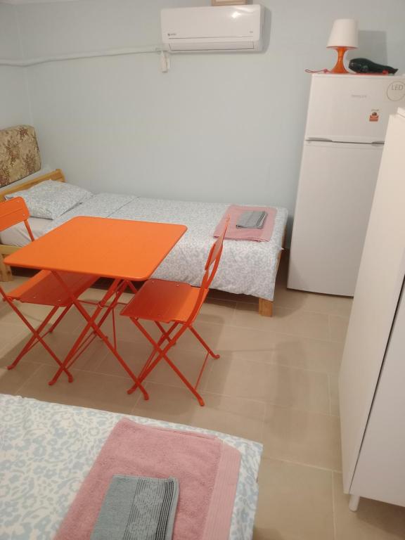 an orange table and chairs in a kitchen with a refrigerator at Christos in Asvestokhórion