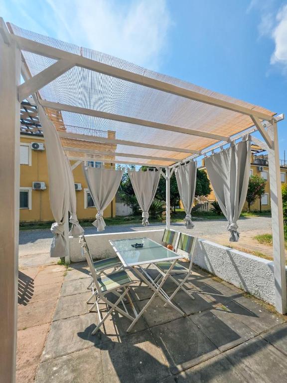 a white pergola with a table and chairs under it at Casa Onde Chiare - Pizzo Beach Club 16G in Fondaco Vecchio