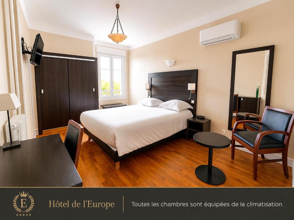 a bedroom with a bed and a table and a chair at Hotel De L'Europe in Toul