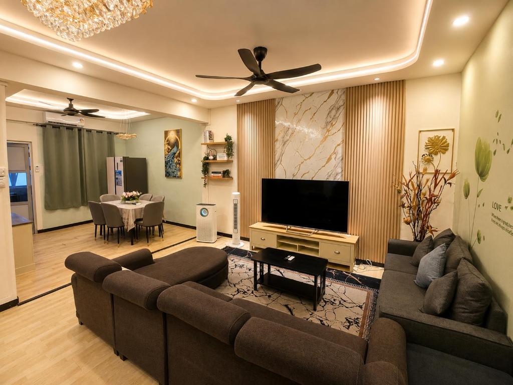 a living room with a couch and a flat screen tv at Arlyn's Homestay in Sandakan
