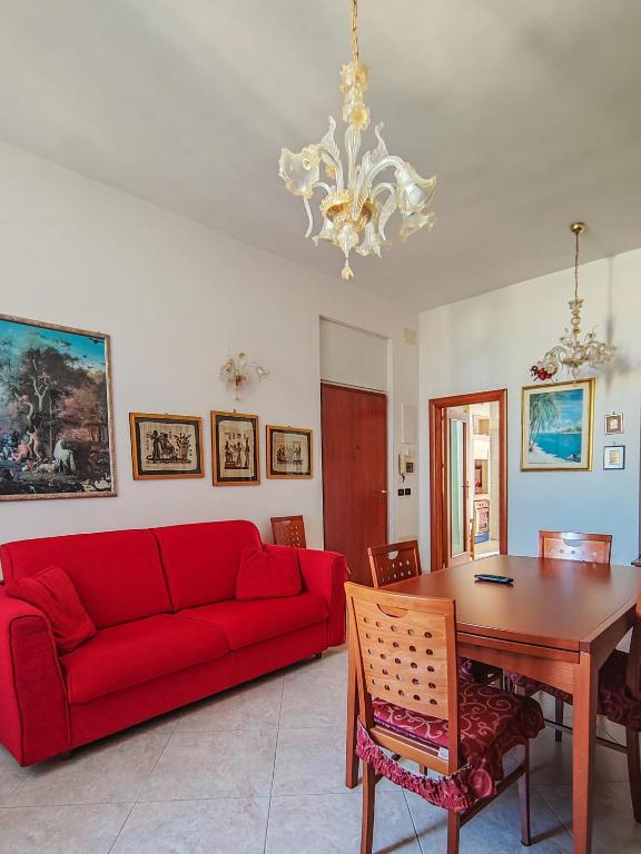 a living room with a red couch and a table at Casa Arcobaleno in Conversano
