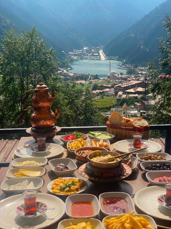 a table filled with plates of food with a view at maneviga pansiyon in Çaykara