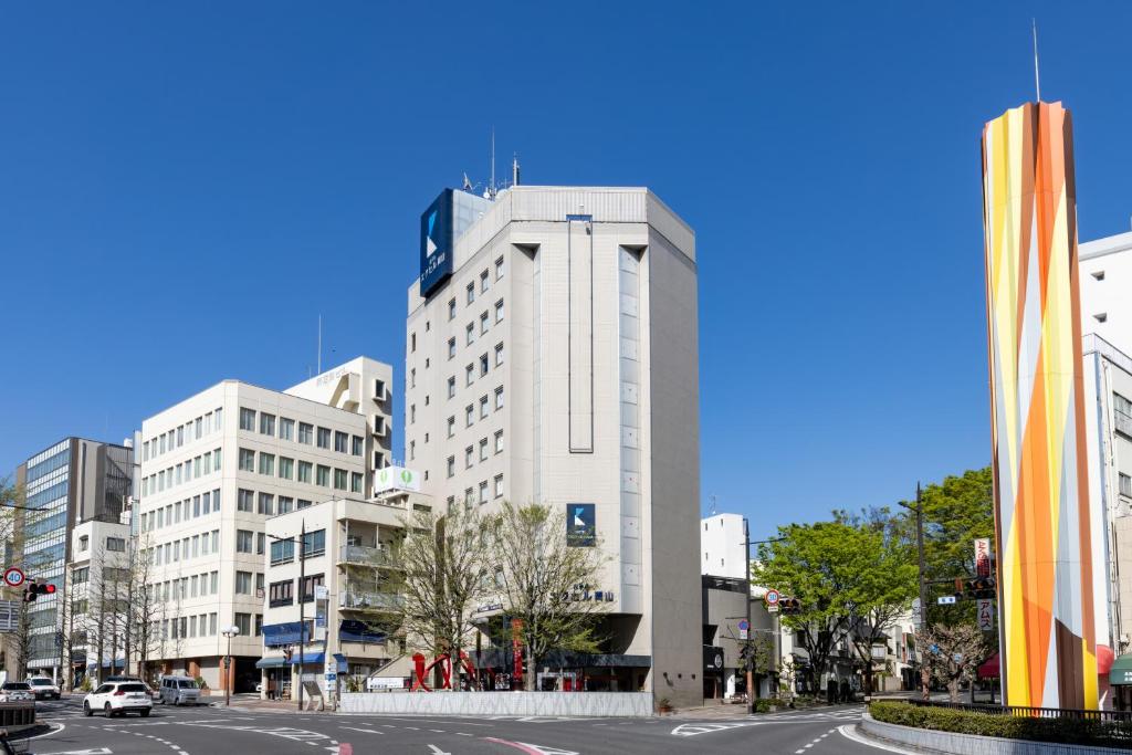 a tall white building on the side of a street at Hotel Excel Okayama in Okayama