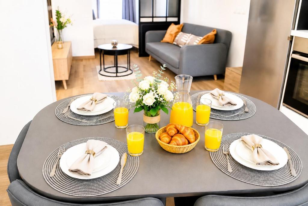 a table with plates of food and glasses of orange juice at La Suite Prestige in Château-Thierry