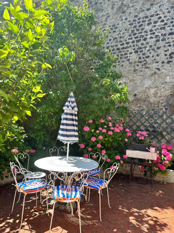 a table and four chairs and a table with a umbrella at Le Petit Paradis in Honfleur