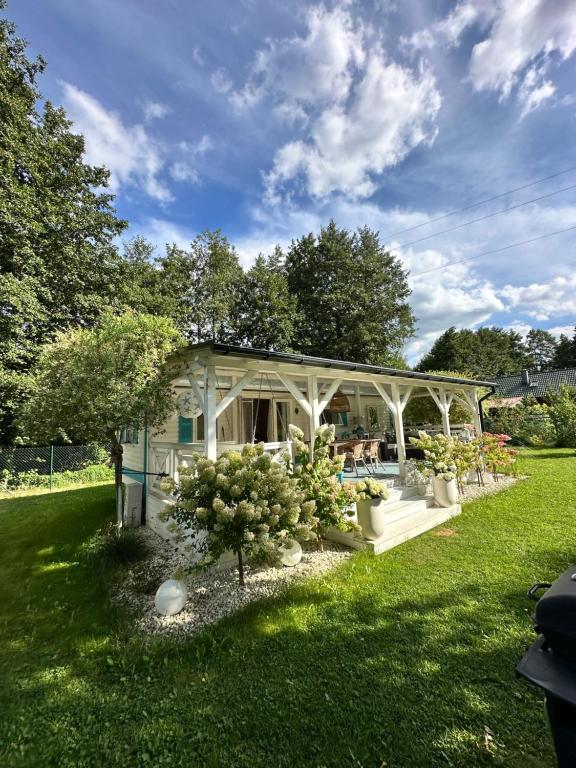 a white house with plants in a yard at Domek holenderski Hampton in Dominice