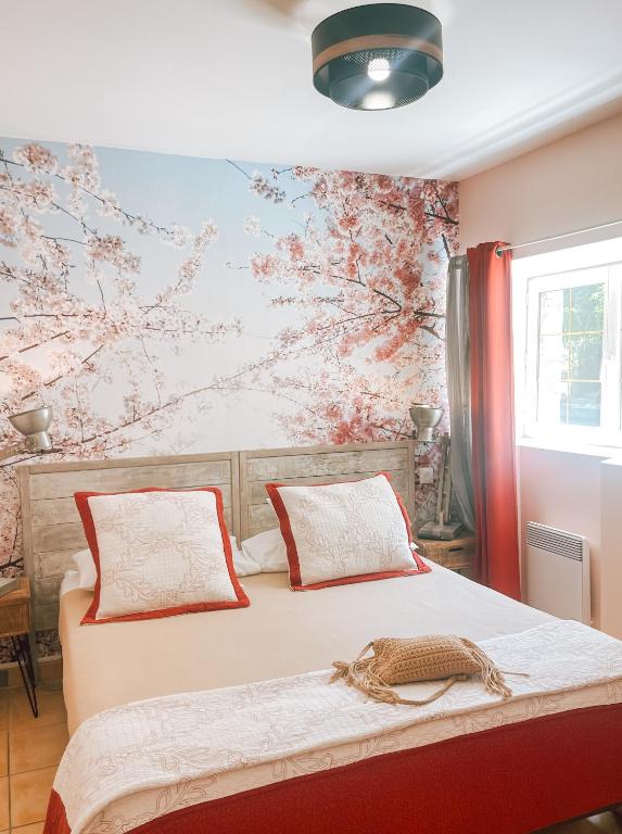 a bedroom with a bed with a floral wall at Logis Hôtel Restaurant Le Domaine de l'Eau Vive in Largentière