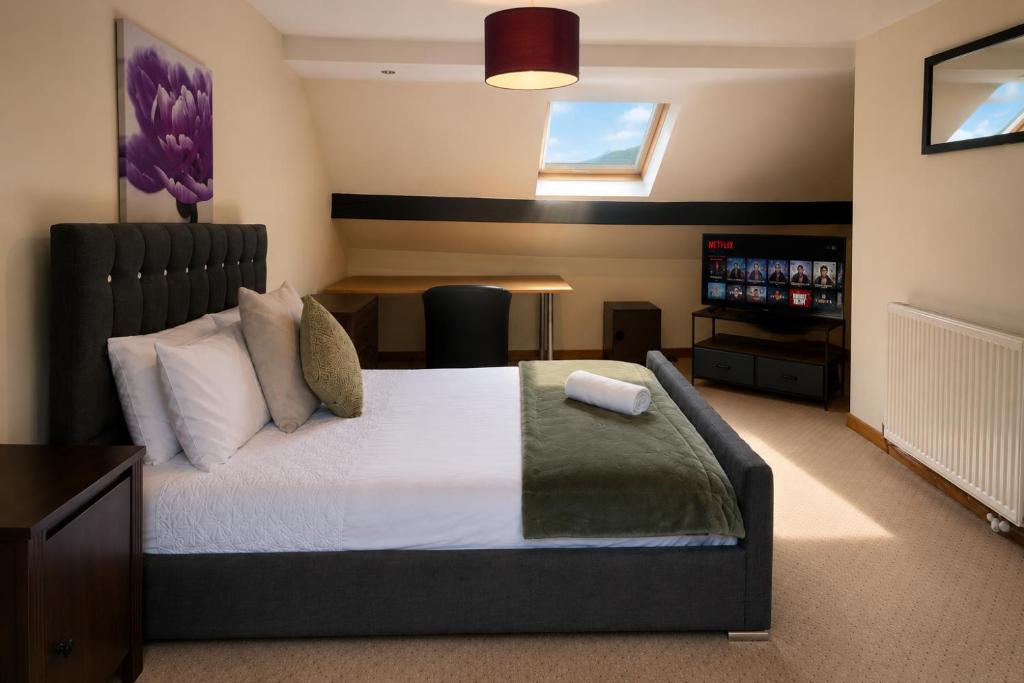 a bedroom with a large bed and a table at 54 - Room 4 - Very spacious in Swansea