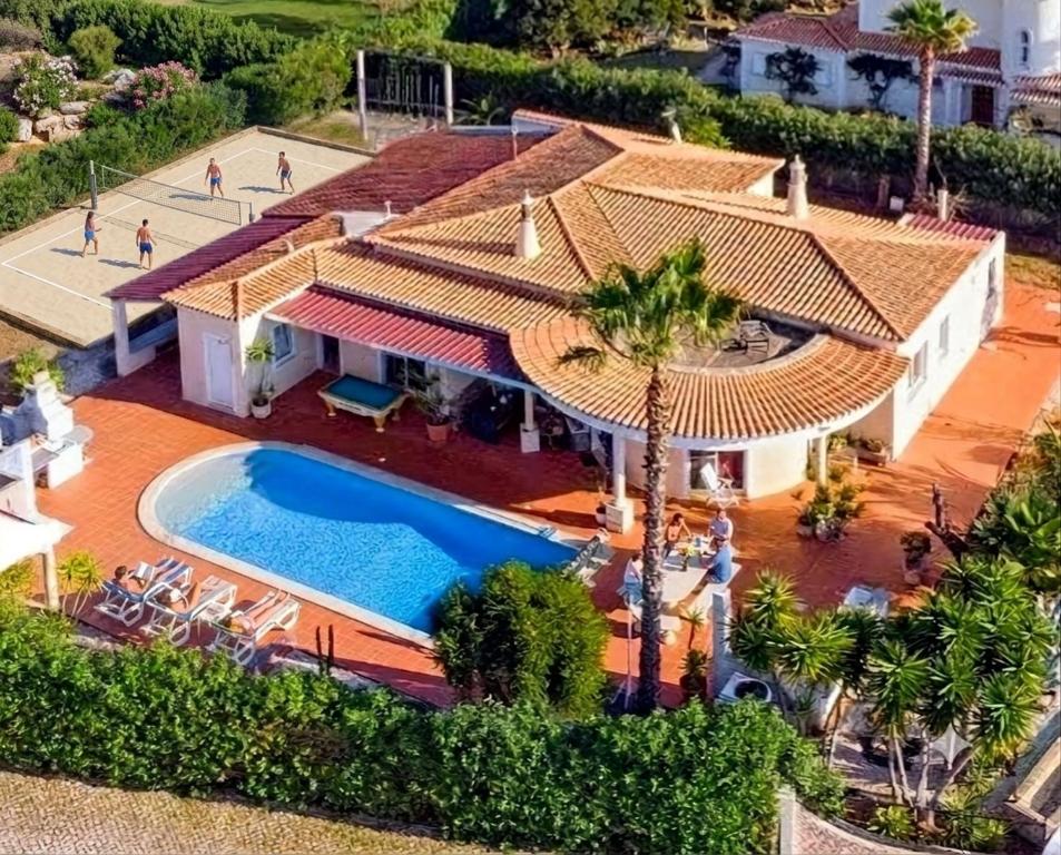 an aerial view of a house with a swimming pool at ALGARVE ONE - 8 rooms, 2 kitchens, private pool, billiard table and Beach-Volleyball Court in Carvoeiro